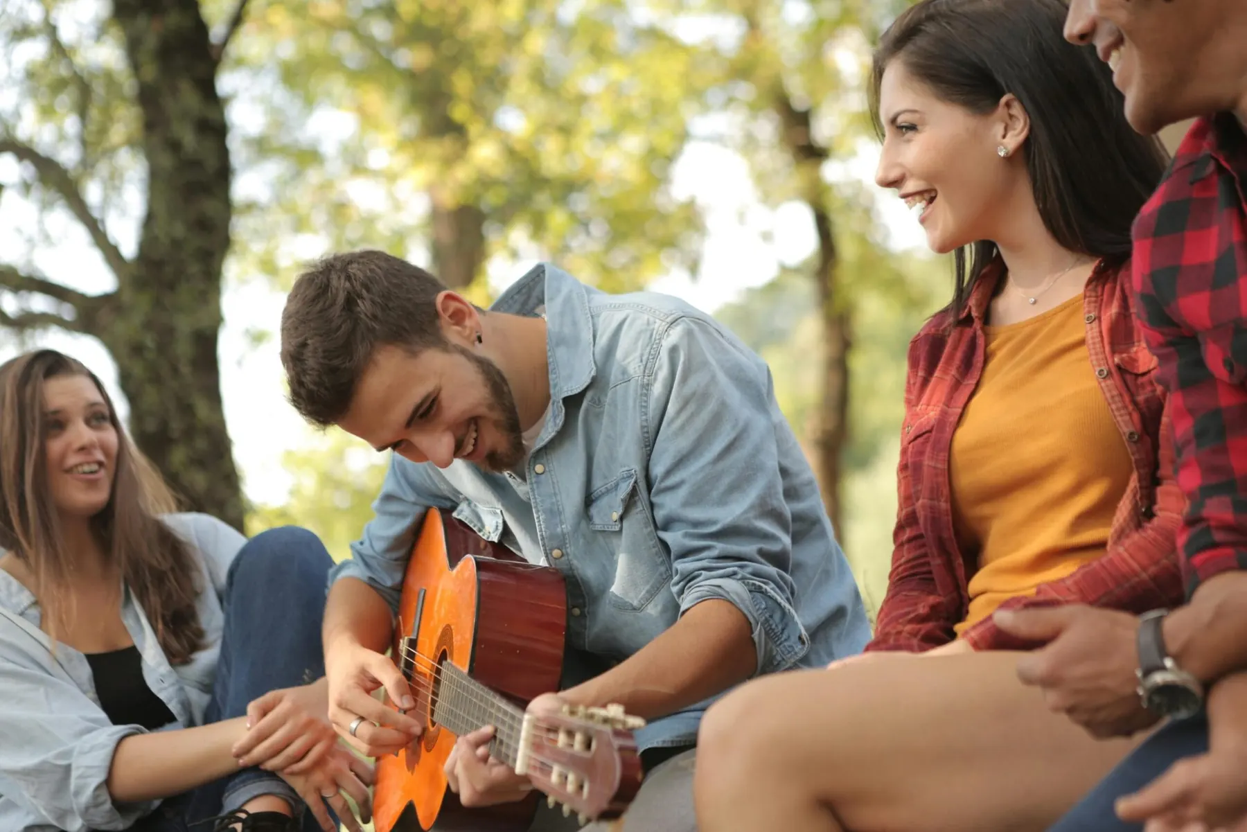 Friends sitting together on the grass in a park
